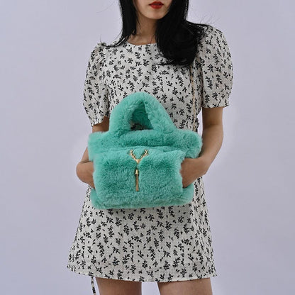 Fluffy turquoise handbag with gold hardware.