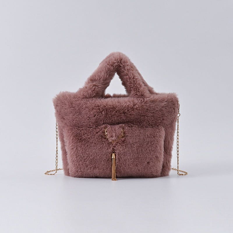 Fluffy mauve handbag with a gold chain strap and tassel detail.