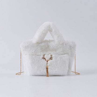 Fluffy white handbag with gold chain straps and a decorative tassel.