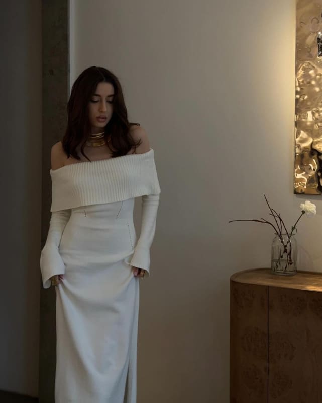 Woman wearing a long white off-shoulder dress.