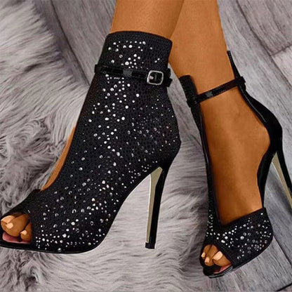 Sparkly black high-heeled peep-toe ankle boots with rhinestone embellishments and ankle straps.