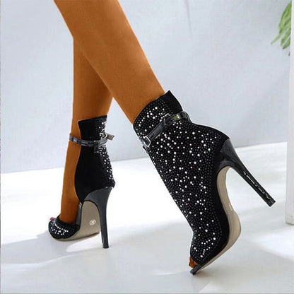 Sparkly black high-heeled ankle boots with peep toes and ankle straps.