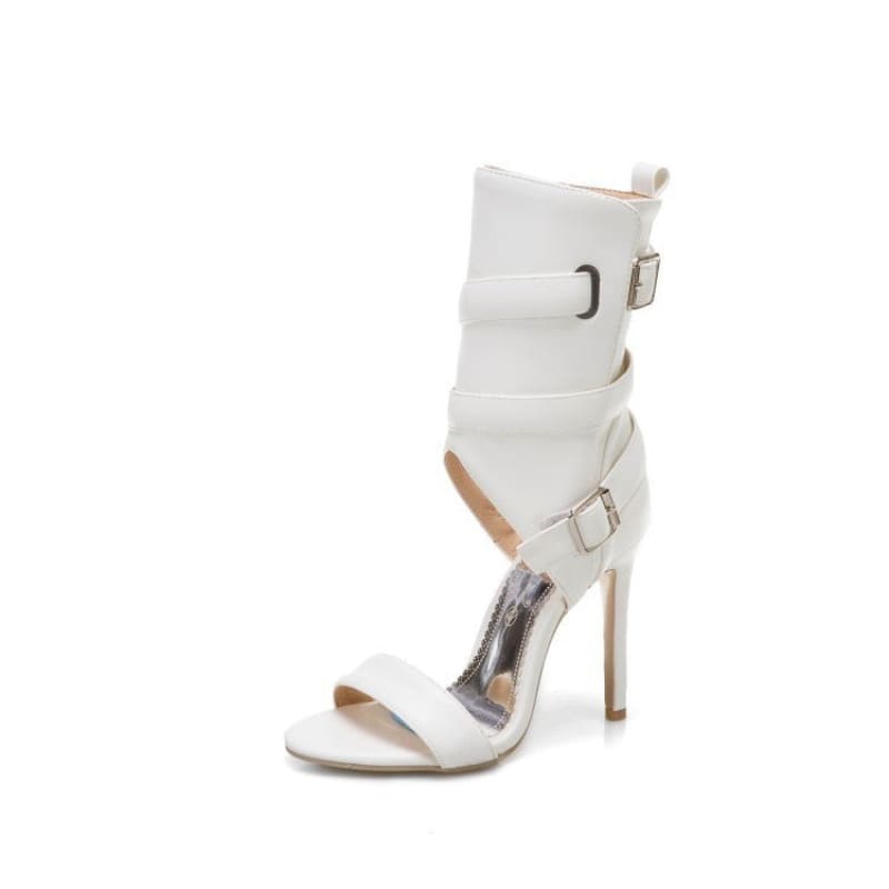 White high-heeled sandal with ankle straps and buckle details.