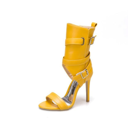 Yellow high-heeled sandal with multiple straps and buckles.