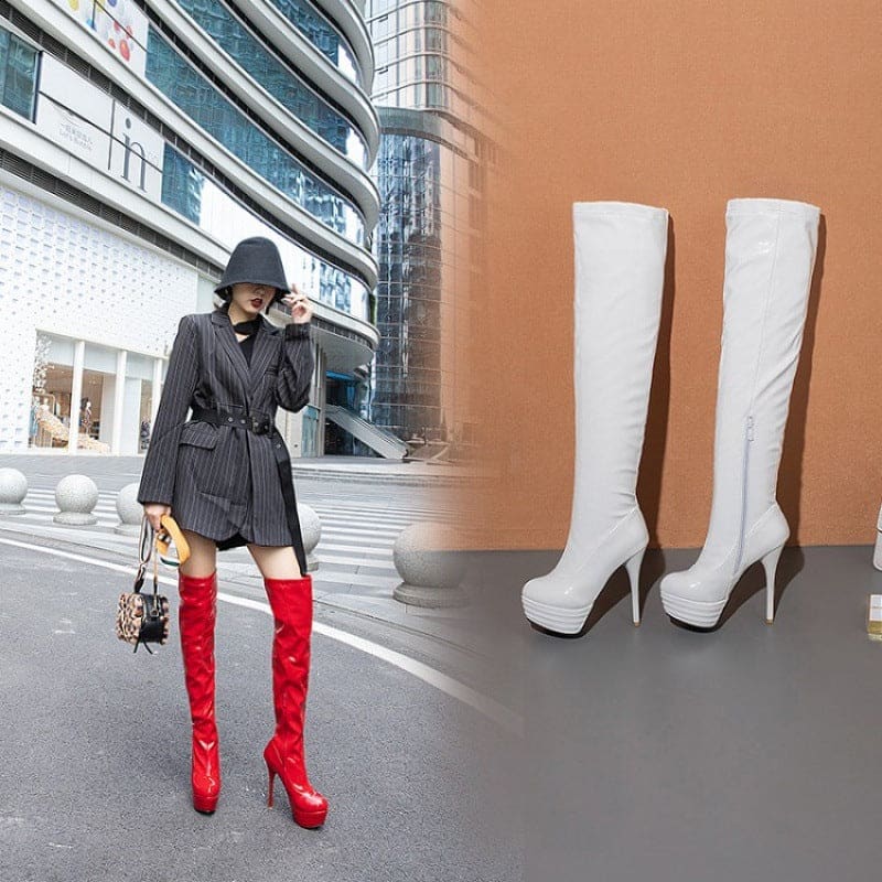 Woman wearing a pinstriped blazer and red thigh-high boots on a city street.