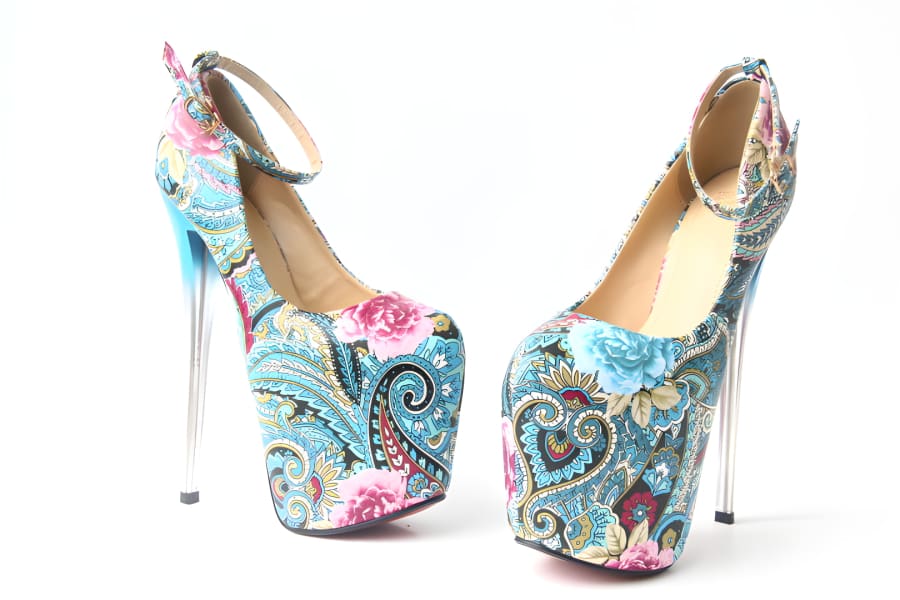 Pair of extremely high-heeled platform shoes with colorful floral and paisley patterns.