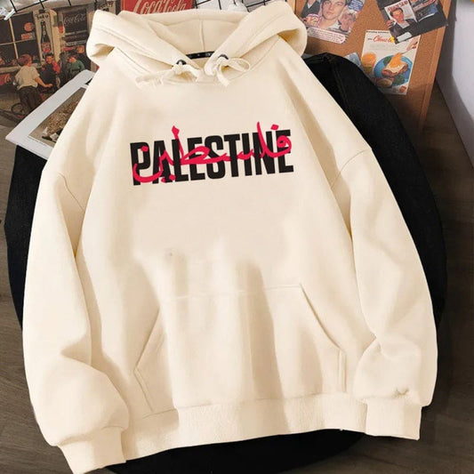 Cream-colored hoodie with ’PALESTINE’ printed in black and pink letters on the front.