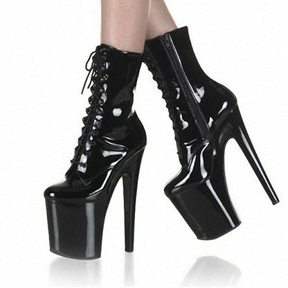 Extremely high platform stiletto ankle boots with lace-up front in shiny black material.