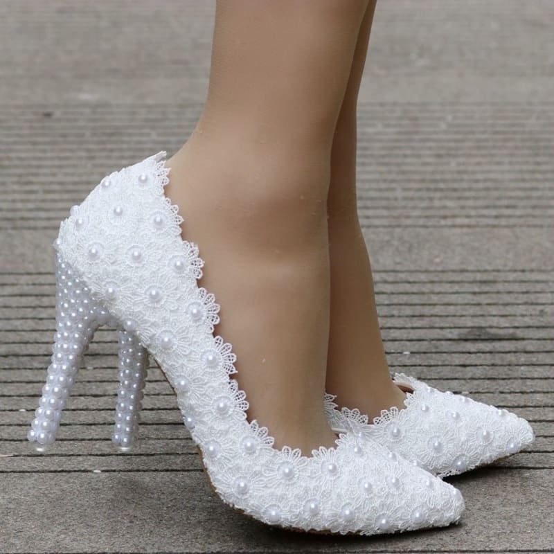 White high-heeled pump adorned with lace and pearls.