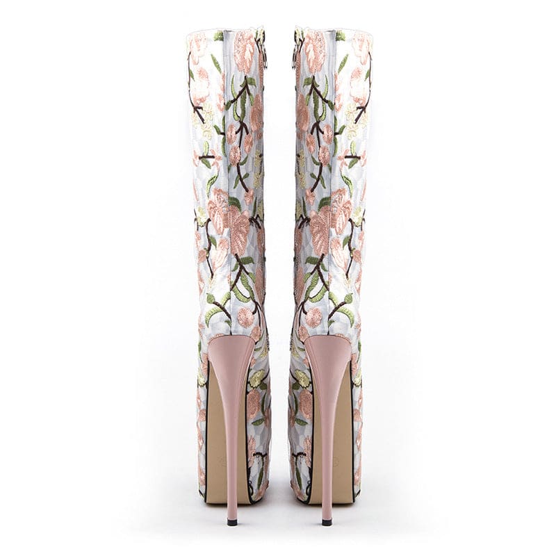 Pair of high-heeled boots with floral embroidery design.