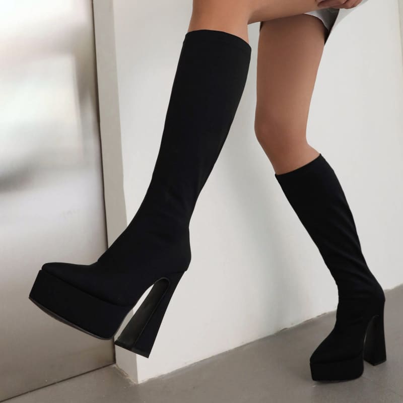 Pair of black knee-high platform boots with chunky heels.