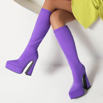 Pair of bright purple knee-high platform boots with chunky heels.