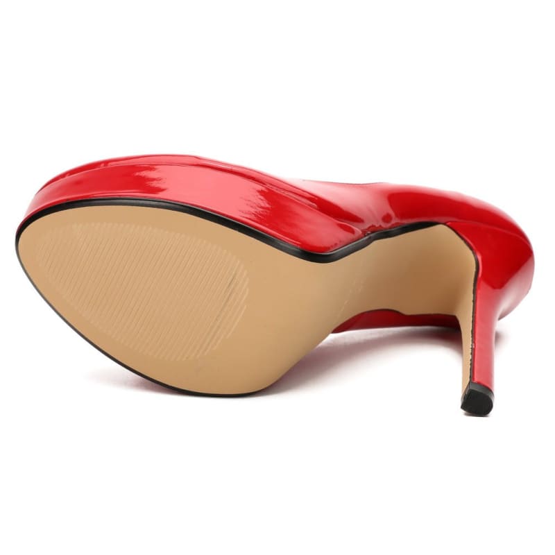 Red patent leather high heel shoe with a pointed toe and thin stiletto heel.