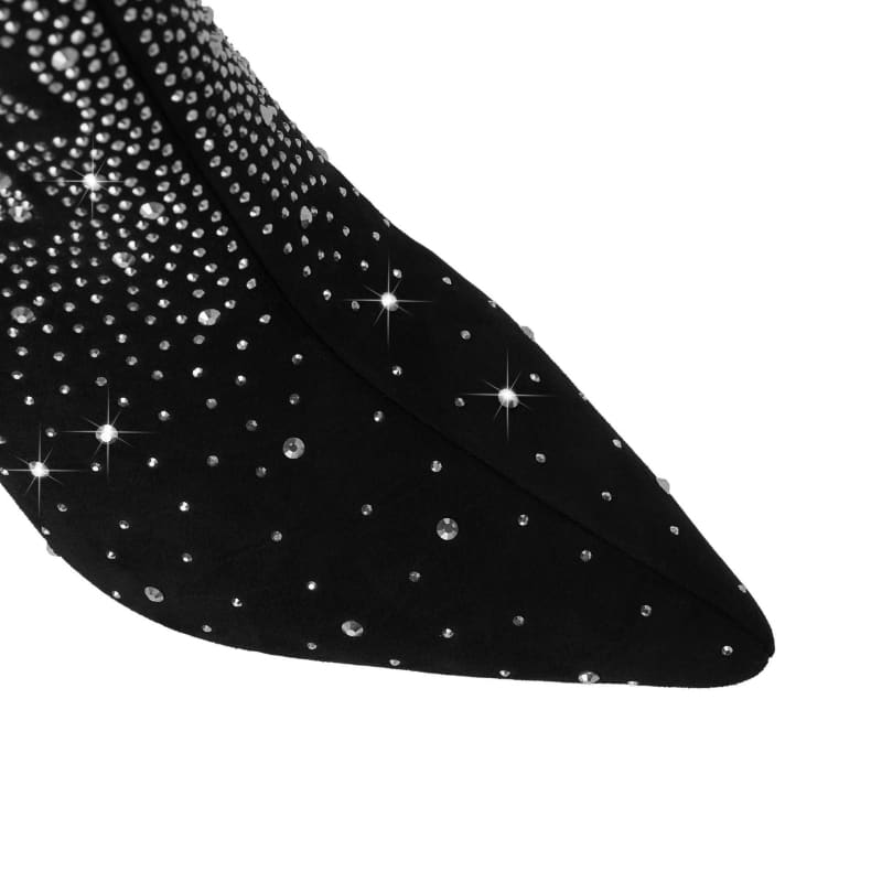 Pointed black shoe adorned with sparkling rhinestones or crystals.