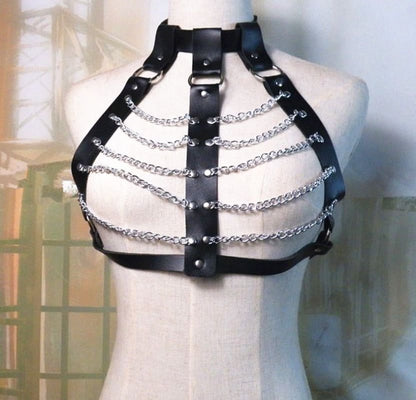 Leather harness with silver chains worn on a mannequin torso.