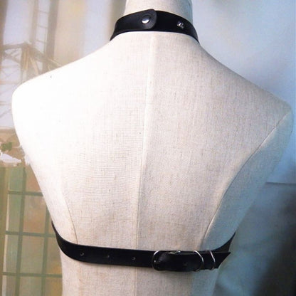 Mannequin torso wearing a black leather harness or collar.