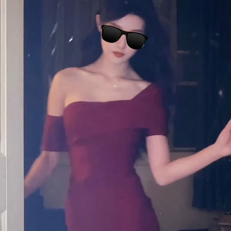 Woman wearing a burgundy off-shoulder dress and dark sunglasses.