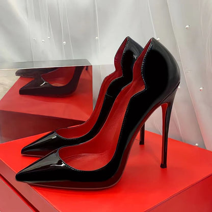 Pair of glossy black high-heeled stiletto pumps with red soles.