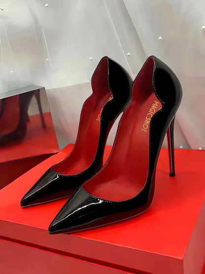 Pair of glossy black stiletto high heels with red soles.