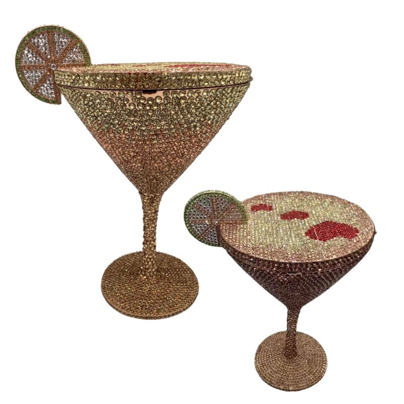 Glittery, jewel-encrusted cocktail glasses shaped like martini glasses, one with a decorative lime slice.