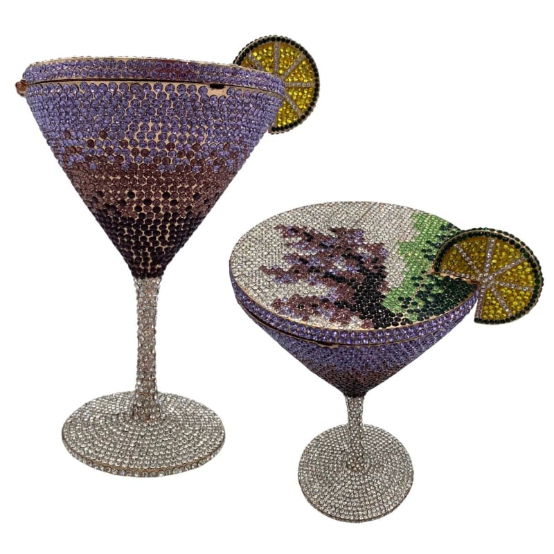 Two bejeweled cocktail glasses adorned with crystal-like decorations and lime slice garnishes.