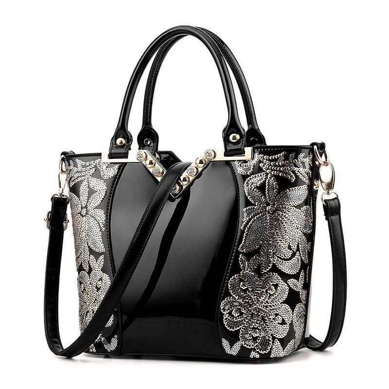 Elegant black handbag with silver floral embroidery and dual handles.