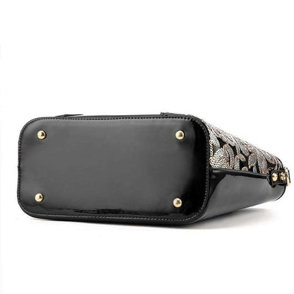 Designer handbag with a patterned fabric body and black leather bottom.