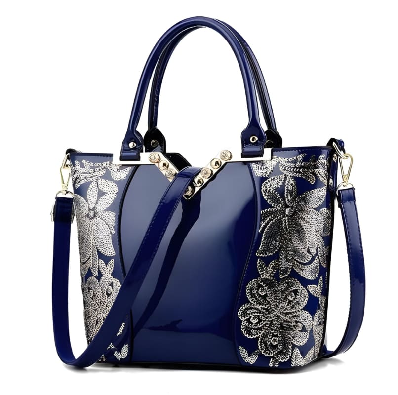 Navy blue handbag with silver floral embroidery and dual handles.