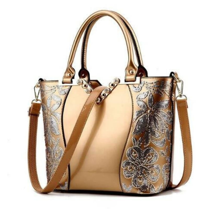 Elegant beige handbag with metallic floral embroidery and dual handles.