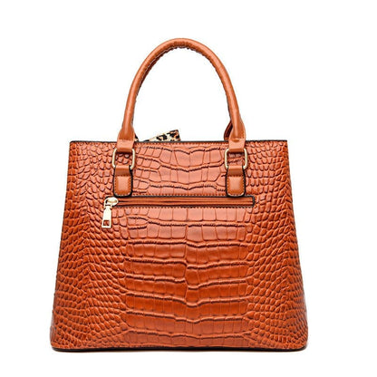 Brown leather handbag with crocodile-embossed texture and structured shape.