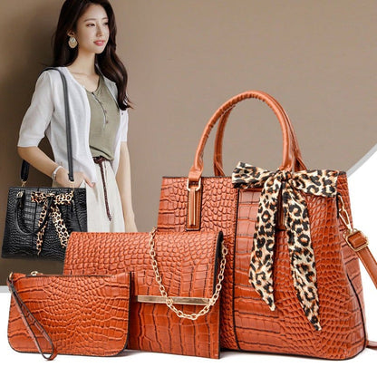 Set of orange crocodile-textured handbags with leopard print scarf accent.