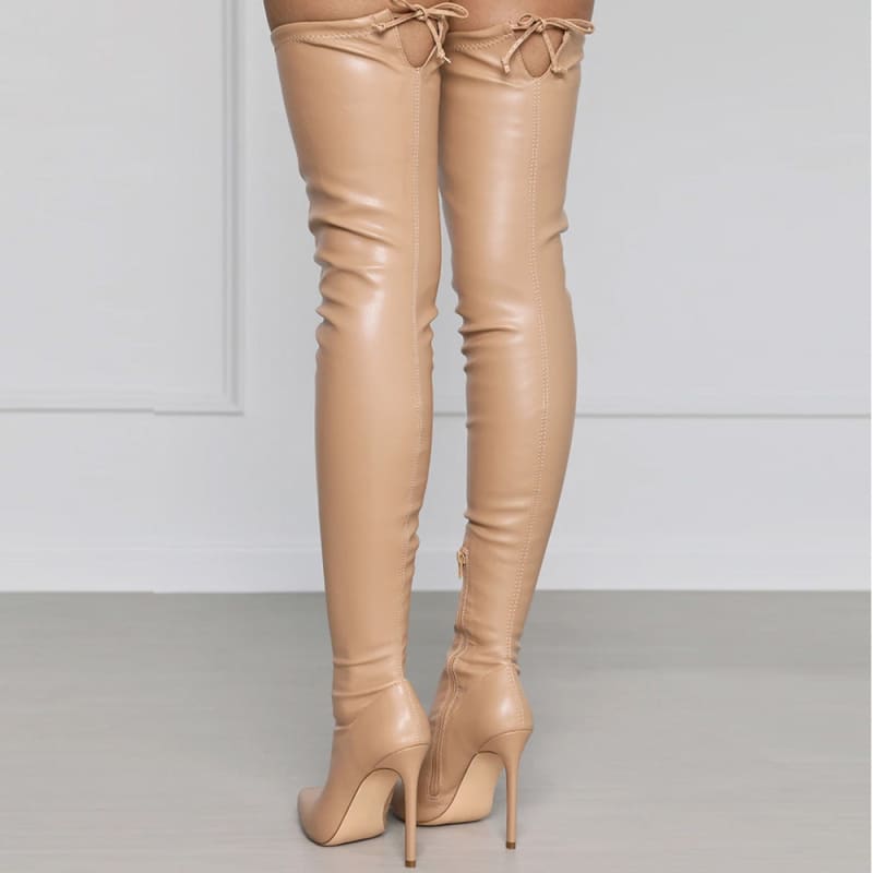 Pair of nude-colored thigh-high stiletto boots with lace-up detailing at the top.