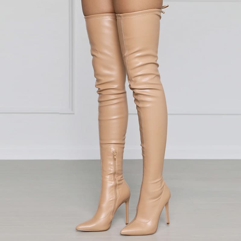 Pair of nude-colored thigh-high stiletto boots with pointed toes.