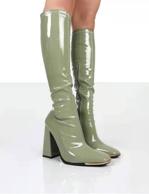 Pair of knee-high, glossy sage green boots with chunky heels.