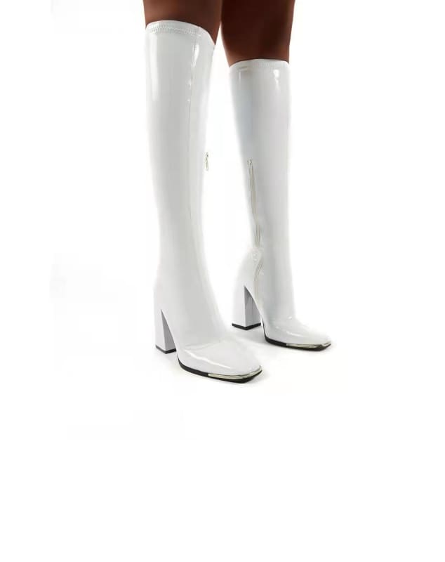 Pair of white knee-high boots with chunky heels.