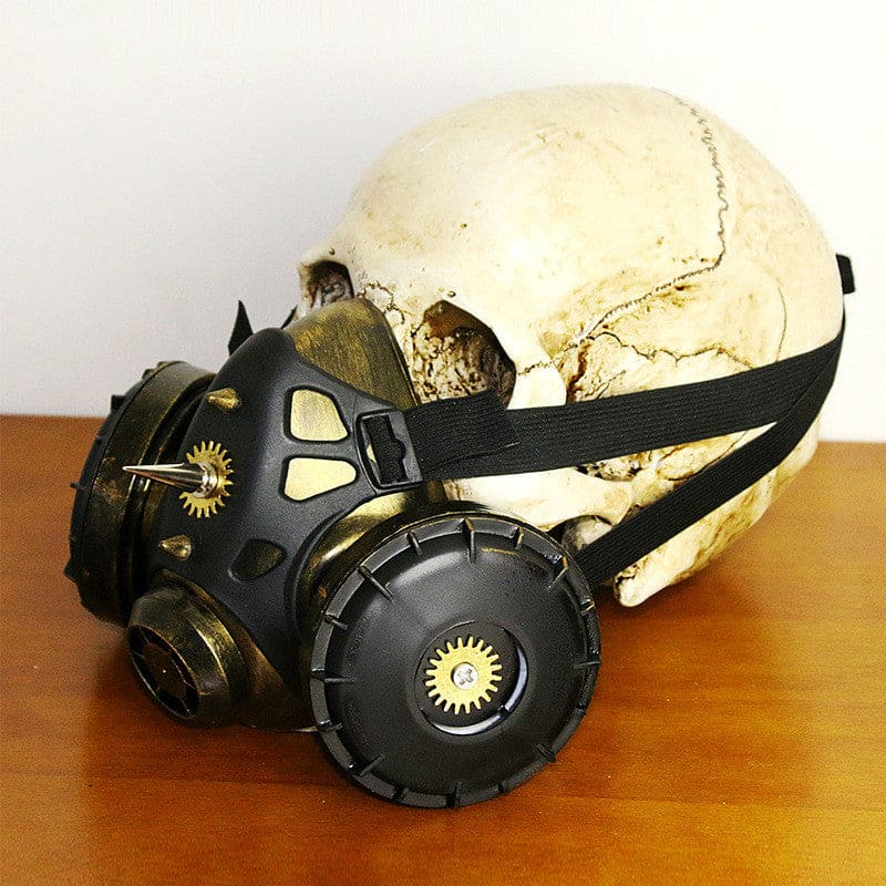 Human skull wearing a black gas mask with gold sun symbols.