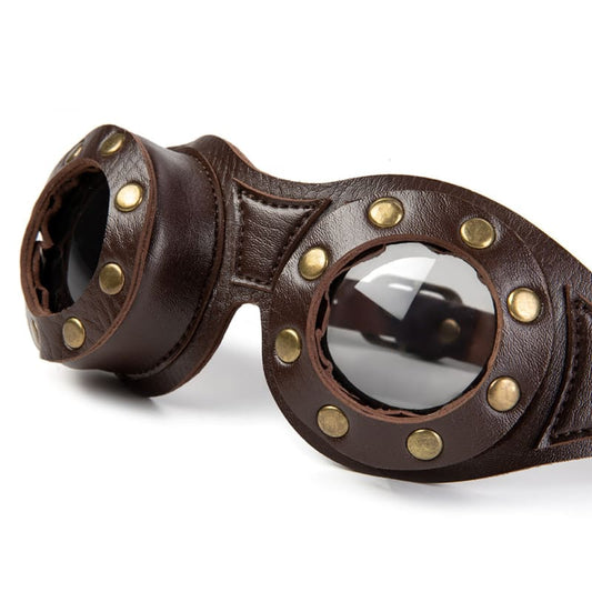 Pair of brown leather steampunk-style goggles with brass studs and dark lenses.