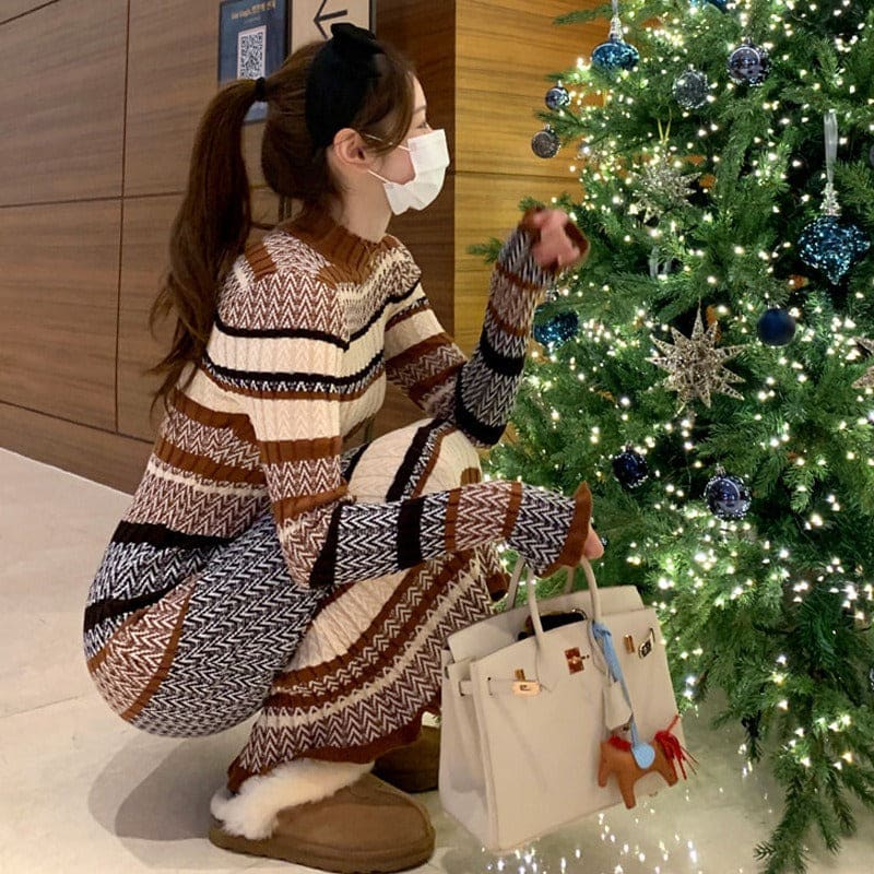 Person wearing a patterned sweater dress decorating a Christmas tree.