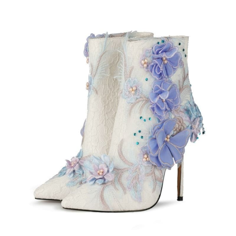 Ornate white ankle boot with lavender floral embellishments and a stiletto heel.