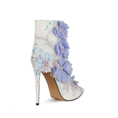 High-heeled white boot adorned with lavender floral appliqués and turquoise beading.