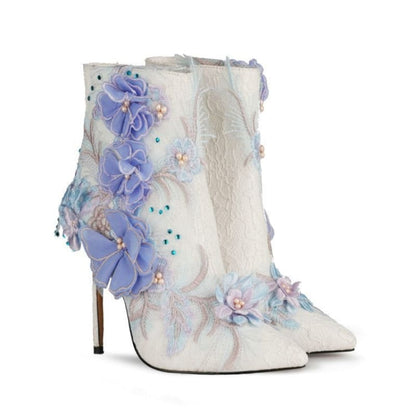 Ornate white ankle boot with lavender floral embellishments and a stiletto heel.