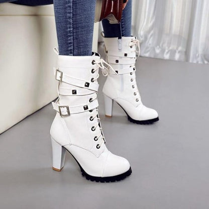 White high-heeled ankle boots with laces, studs, and buckle straps.