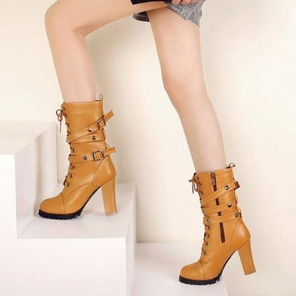 Pair of tan leather high-heeled boots with multiple buckles and straps.