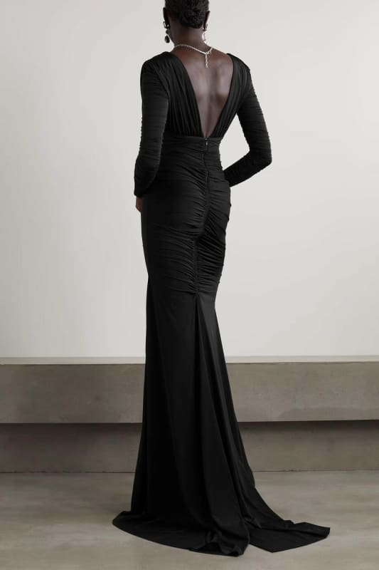 Long, form-fitting black evening gown with a plunging back.