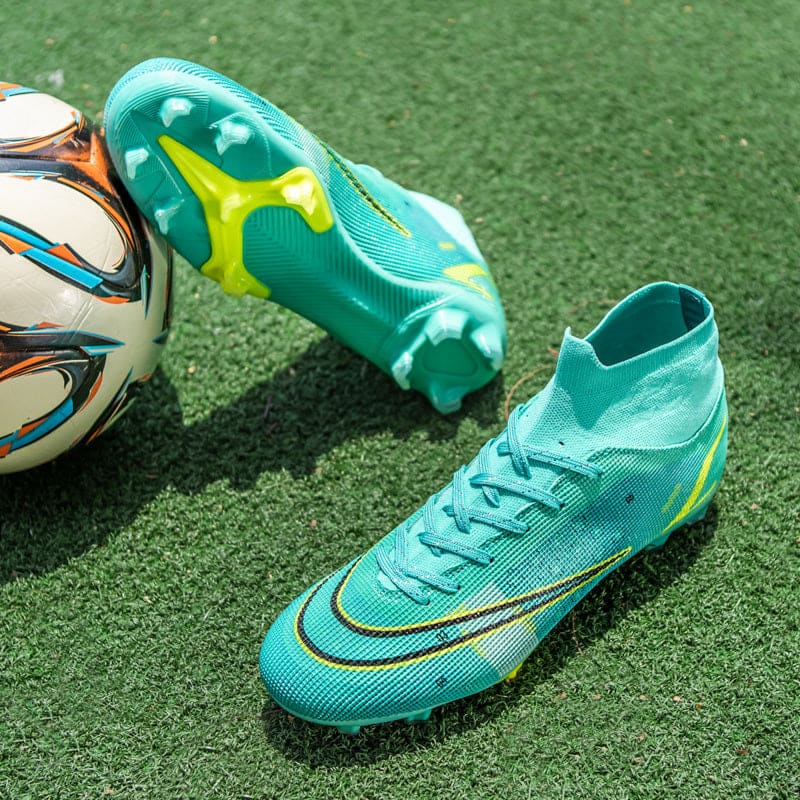 Pair of teal and yellow high-top soccer cleats with a soccer ball beside them.