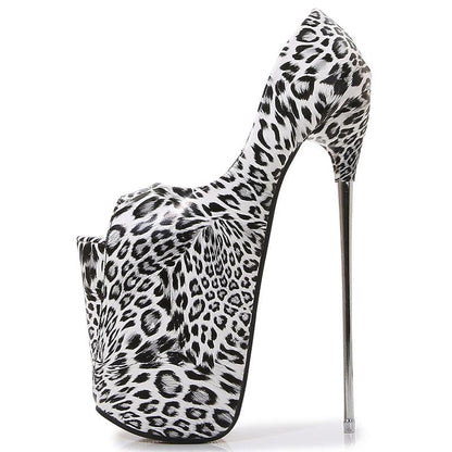 Extremely high-heeled platform shoe with black and white leopard print pattern.