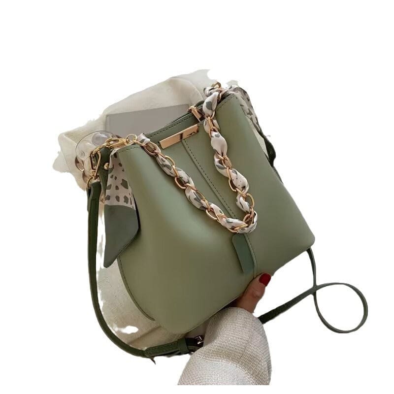 Green leather handbag with a decorative chain strap and gold hardware.