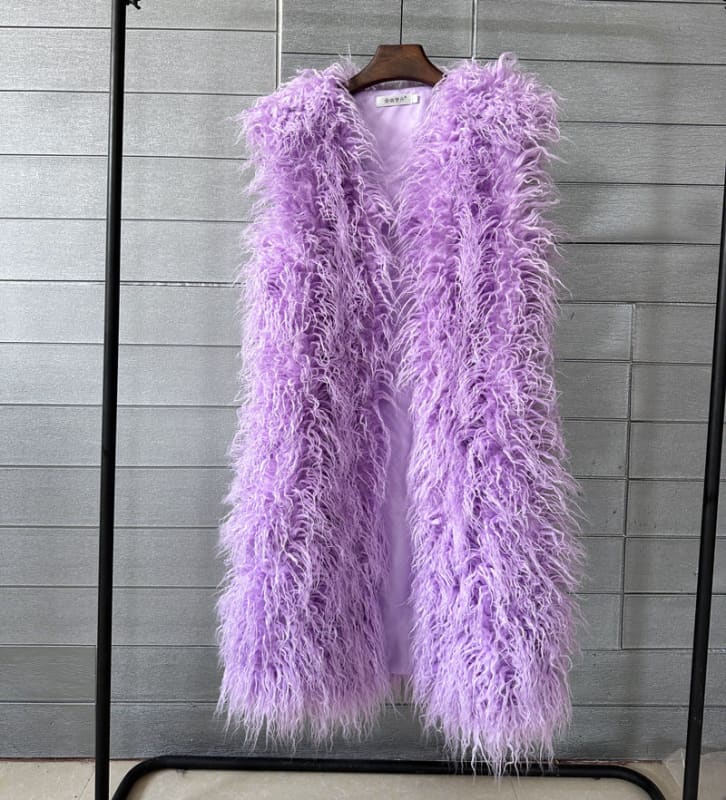 Fluffy lavender faux fur vest hanging on a wooden hanger.