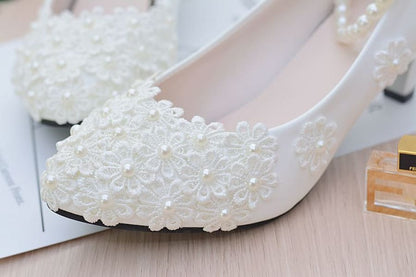 Elegant white bridal shoe adorned with delicate floral lace and pearls.