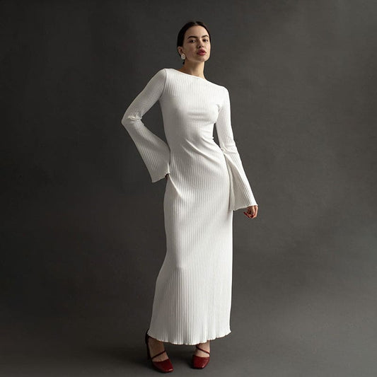 Long white ribbed dress with bell sleeves and a high neckline.